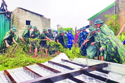Cán bộ, chiến sĩ Trung đoàn 841 giúp người dân xã Cẩm Trung khắc phục thiệt hại do tố, lốc gây ra.