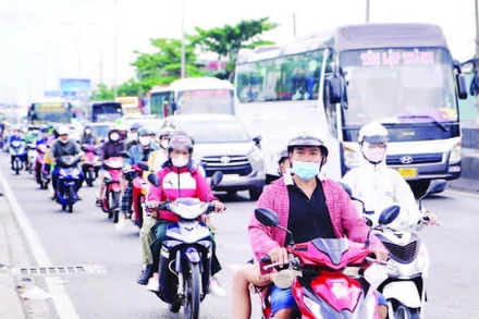 Xe máy lưu thông trên Quốc lộ 1, đoạn qua cầu Bình Điền. (Ảnh THẾ ANH)