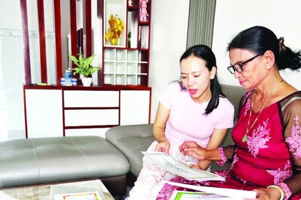 Bà Dư Thị Ánh (68 tuổi) bên những tấm bằng khen, giấy chứng nhận thành tích học tập của con cháu được gìn giữ cẩn thận.