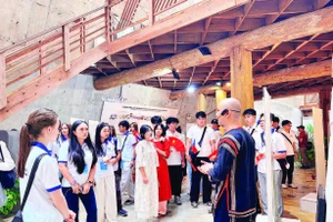1. Các thanh niên kiều bào tham quan nhà dài truyền thống của dân tộc Ê Đê tại Bảo tàng Thế giới cà-phê.
