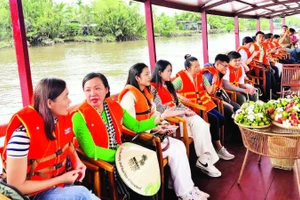 Du khách tham quan bằng tàu du lịch dọc dòng sông Thom (xã Mỏ Cày, tỉnh Vĩnh Long).