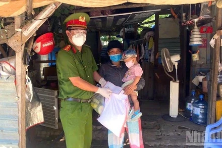 Trung tá Nguyễn Xuân Cường thay mặt lãnh đạo đơn vị đến thăm, tặng quà, động viên các hộ gia đình khó khăn trên địa bàn quận Liên Chiểu. (Ảnh: ĐÌNH TĂNG)