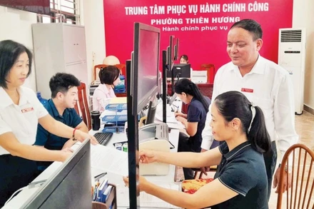 Cán bộ Trung tâm Phục vụ hành chính công phường Thiên Hương hướng dẫn người dân thực hiện thủ tục hành chính. (Ảnh minh họa)