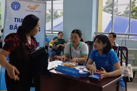 Nhân viên bảo hiểm xã hội tư vấn chế độ, chính sách bảo hiểm xã hội cho người dân Thành phố.