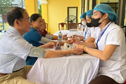 Cán bộ y tế kiểm tra sức khỏe định kỳ cho người dân trên địa bàn Hà Nội.
