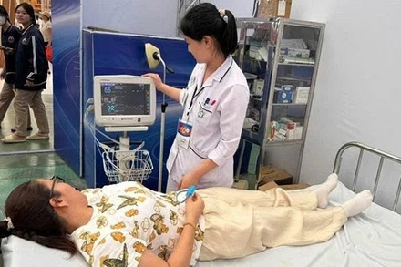 Cán bộ y tế chăm sóc sức khỏe người dân khi tham quan Triển lãm thành tựu đất nước.