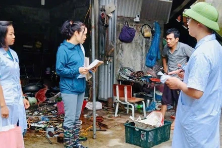 Cán bộ y tế hướng dẫn người dân trên địa bàn thành phố Hà Nội thực hiện các biện pháp phòng, chống dịch bệnh trong mưa, bão