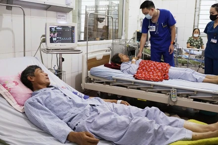 Các bác sĩ kiểm tra sức khỏe 2 bệnh nhân bị sét đánh đang điều trị tại Bệnh viện đa khoa Thanh Oai (Hà Nội).