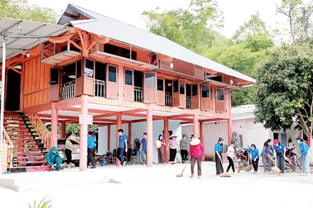 Người dân giúp gia đình ông Nguyễn Viết Đôn ở thôn Đồng Kem, xã Đồng Yên, Tuyên Quang dọn vào nhà mới. (Ảnh: TRỊNH KHÁNH TOÀN)