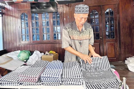 Nghệ nhân Mohamad giới thiệu các sản phẩm dệt truyền thống của người Chăm.