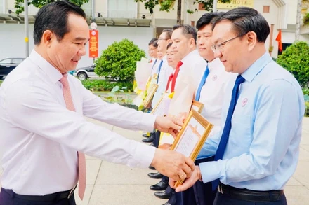 Ông Nguyễn Văn Được, Bí thư Đảng ủy, Chủ tịch Ủy ban nhân dân Thành phố Hồ Chí Minh tặng hoa, giấy khen chúc mừng ông Lâm Đình Thắng, Giám đốc Sở Khoa học và Công nghệ. 