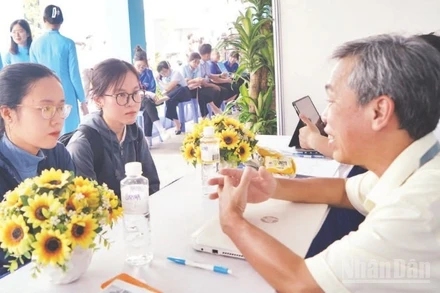 Các sinh viên mới ra trường được tư vấn tại ngày hội việc làm. (Ảnh: THẾ ANH) 