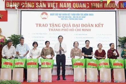Bí thư Trung ương Đảng, Bí thư Thành ủy Thành phố Hồ Chí Minh Trần Lưu Quang tặng quà đại đoàn kết cho các hộ dân trên địa bàn Khu phố 5, phường Bình Thạnh (Ảnh: DUY PHÚ) 