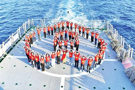 Kiều bào chụp ảnh lưu niệm trên tàu KN390 trong chuyến thăm Trường Sa. (Ảnh: Ủy ban Nhà nước về người Việt Nam ở nước ngoài)