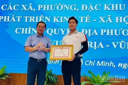 Chủ tịch Ủy ban nhân dân Thành phố Hồ Chí Minh Nguyễn Văn Được tặng bằng khen cho anh Cao Thành Đạt. (Ảnh: Vương Lê) 
