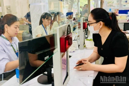 Cán bộ, công chức Thành phố Hồ Chí Minh giải quyết thủ tục hành chính cho người dân. (Ảnh: VƯƠNG LÊ) 