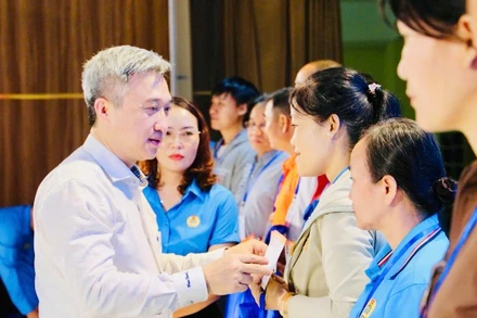 Đồng chí Đặng Minh Thông, Phó Bí thư Thành ủy Thành phố Hồ Chí Minh trao quà cho người lao động có hoàn cảnh khó khăn. 