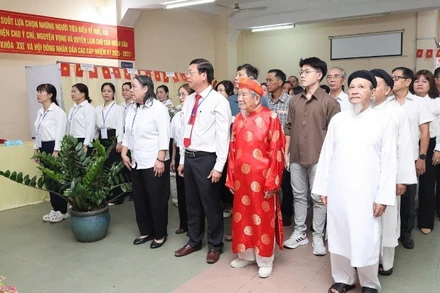 Nhà nghiên cứu Nguyễn Đình Tư (106 tuổi) mặc áo dài đỏ tham gia bầu cử sáng 15/3.