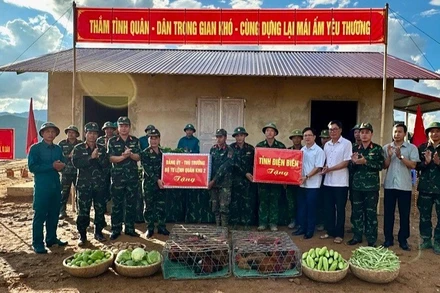 Thiếu tướng Nguyễn Đăng Khải và đồng chí Phạm Đức Toàn, Phó Chủ tịch Ủy ban nhân dân tỉnh Điện Biên trao quà, động viên các cán bộ, chiến sĩ đang giúp nhân dân làm nhà ở mới tại điểm tái định cư bản Háng Pù Xi, xã Xa Dung. (Ảnh: ĐỨC HẠNH)