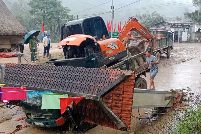 Hiện trường vụ tai nạn xe tải chở xe múc húc đổ cổng làng khiến 2 người tử vong.