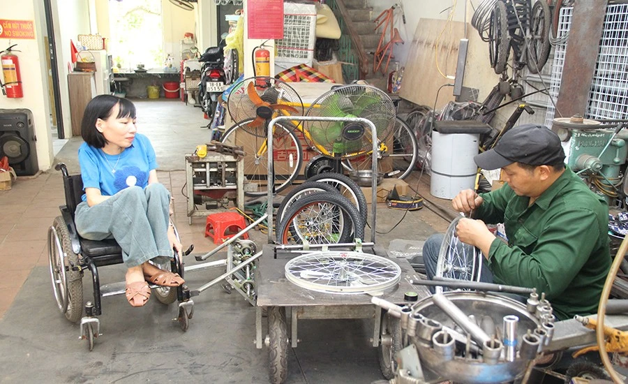 Chị Nga trao đổi với người đồng hành về ý tưởng thiết kế xe ba bánh cho người khuyết tật.