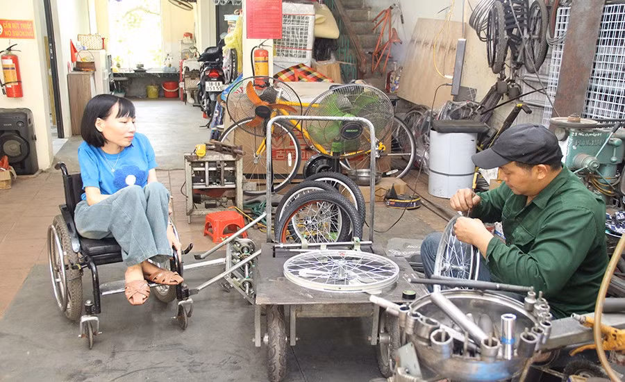 Chị Nga trao đổi với người đồng hành về ý tưởng thiết kế xe ba bánh cho người khuyết tật.