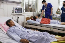 Các bác sĩ kiểm tra sức khỏe 2 bệnh nhân bị sét đánh đang điều trị tại Bệnh viện đa khoa Thanh Oai (Hà Nội).
