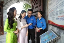 Đoàn viên, thanh niên tỉnh Bắc Giang hướng dẫn người dân quét mã QR khi đến tham quan Khu di tích chiến thắng Xương Giang. (Ảnh: DANH LAM)