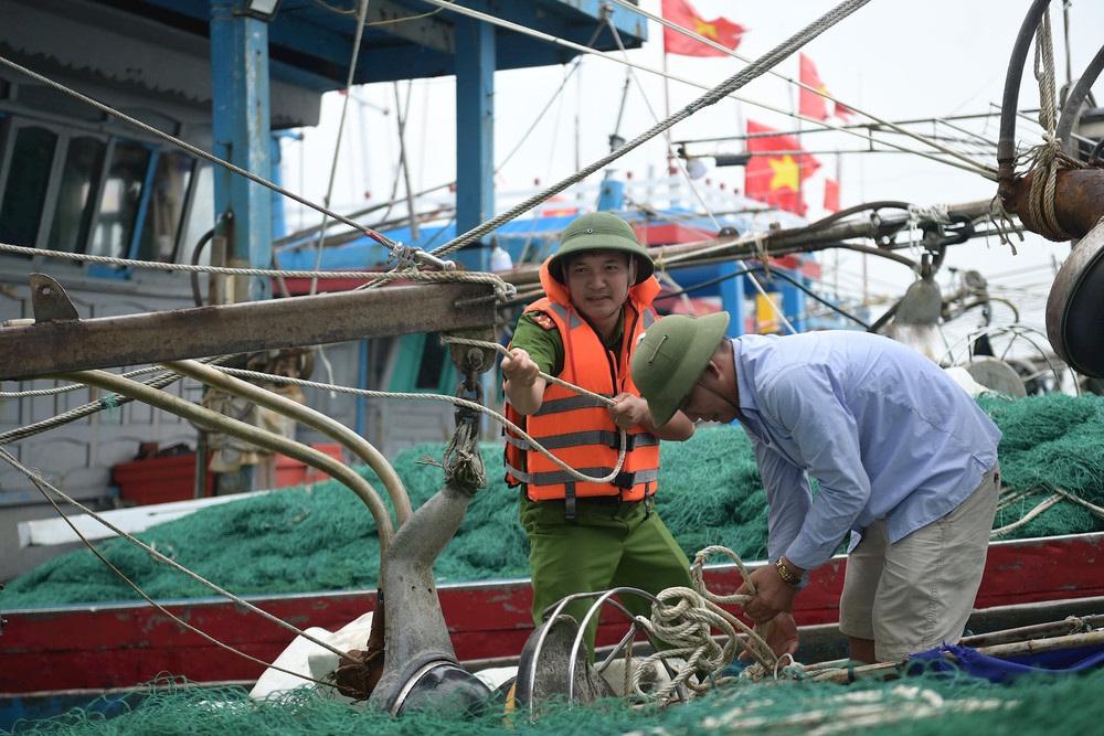 Lực lượng chức năng hỗ trợ ngư dân thu dọn ngư cụ, chằng buộc tàu thuyền tại tỉnh Ninh Bình. (Ảnh THẾ TÙNG) dsc-8177.jpg