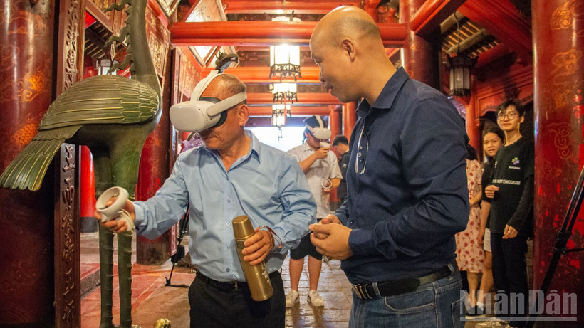 Khách du lịch thích thú khi được trải nghiệm hệ thống thực tế ảo tại di tích Văn Miếu-Quốc Tử Giám. (Ảnh: HÀ NAM)