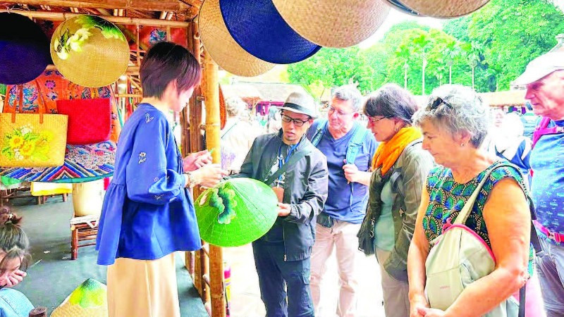 Khách quốc tế tìm hiểu sản phẩm thủ công mỹ nghệ tại Festival Thăng Long-Hà Nội.