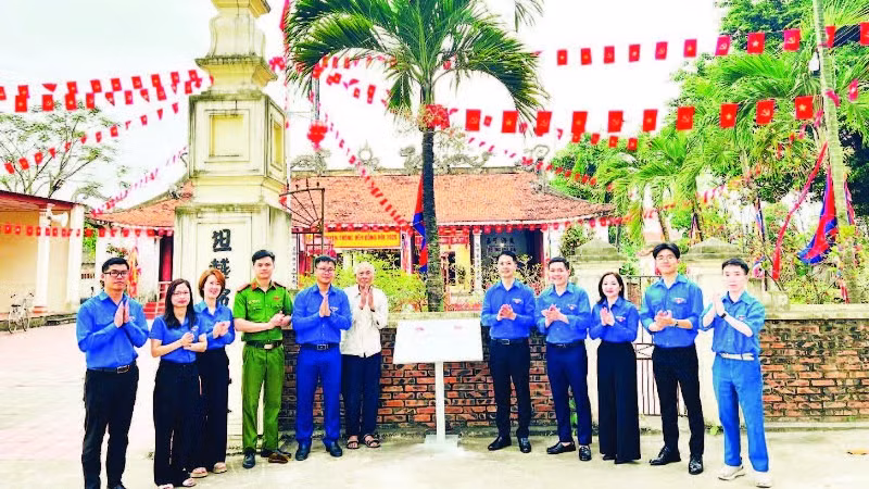 Đoàn viên thanh niên tổ chức gắn biển số hóa di tích tại Đình Đông Hội (Ảnh NINH BÌNH)