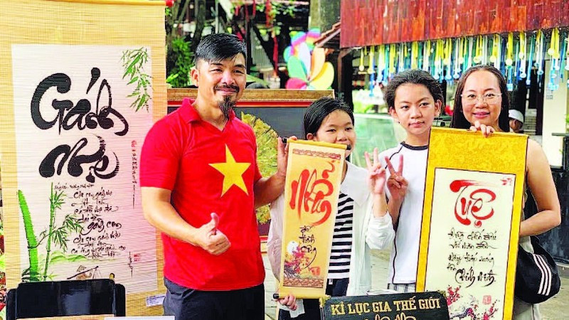 Nghệ nhân Võ Dương cho chữ tại gian hàng Ông đồ. (Ảnh Nhân vật cung cấp)