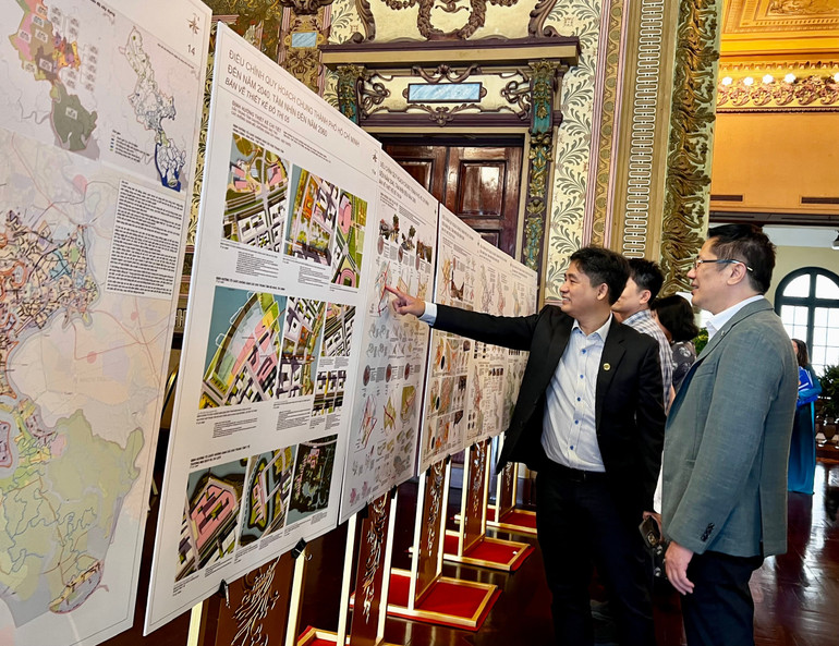 Đại diện Công ty Trách nhiệm hữu hạn một thành viên Không Gian Xanh (Green Space), đơn vị phối hợp thực hiện đồ án cùng các đại biểu tham quan các quy hoạch phân khu của đồ án. (Ảnh: THẾ ANH) 678c0bf94b3bfc65a52a.jpg