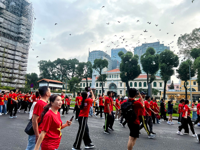 Người dân thích thú với hình ảnh những đàn chim bồ câu bay trên bầu trời trên cung đường đi bộ (Ảnh: QUANG QUÝ) z6912036945263-f7efc20bb11ce05c62bc71a7b6cf199d.jpg