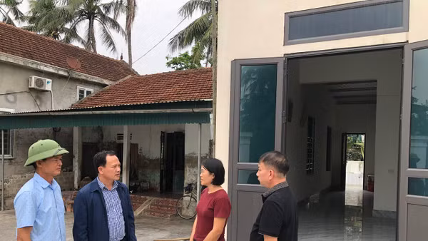 Cán bộ xã Đức Châu (Nghệ An) trao đổi với hộ nghèo được hỗ trợ xây nhà