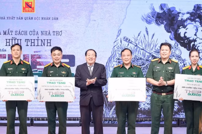 Nhà thơ Hữu Thỉnh và đại diện Nhà xuất bản Quân đội nhân dân tặng sách cho các đơn vị trong quân đội.
