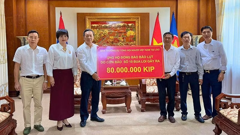 Đại diện Tổng hội người Việt Nam tại Lào ủng hộ đồng bào trong nước chịu ảnh hưởng bão lũ. (Ảnh: Cộng tác viên) 