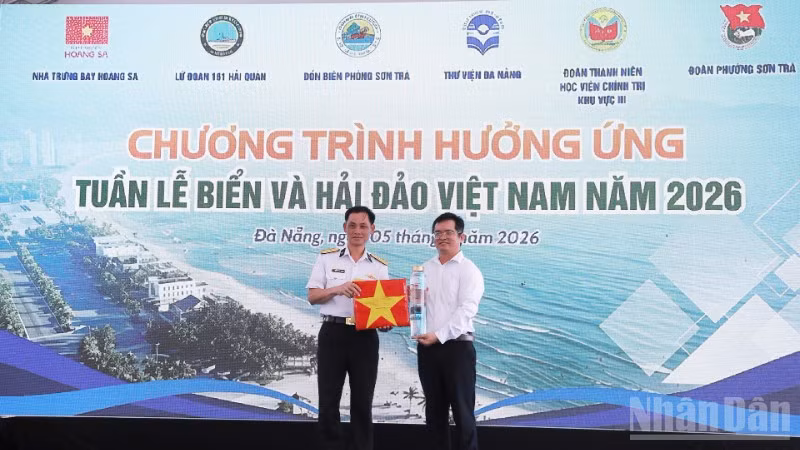 Thượng tá Nguyễn Công Khương, Phó Lữ đoàn trưởng, Lữ đoàn 161 trao tặng mẫu nước biển lấy từ vùng biển Hoàng Sa cùng cờ Tổ quốc của các tàu thực hiện nhiệm vụ trên biển.