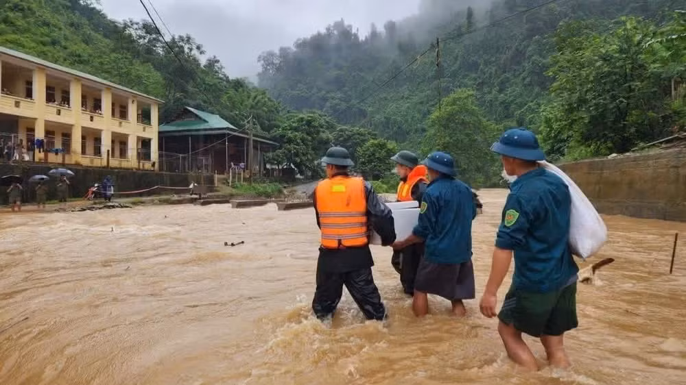 Cán bộ, chiến sĩ Đồn Biên phòng Tam Hợp và Ban Chỉ huy quân sự xã Tam Thái, tỉnh Nghệ An, đưa cơm cho học sinh điểm trường bán trú bị mưa lũ chia cắt. (Ảnh: TRUNG HIẾU) 