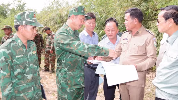 Lực lượng chức năng hai bên trao đổi thông tin trên bản đồ.