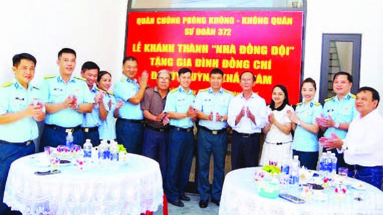 Các đại biểu bàn giao “Nhà đồng đội” chụp ảnh lưu niệm với gia đình Đại úy Huỳnh Khắc Tâm. (Ảnh VĂN TÂM). 10.jpg