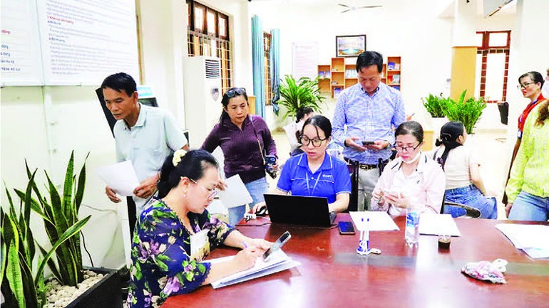 Các thành viên tổ công nghệ số cộng đồng hướng dẫn người dân giải quyết thủ tục hành chính trực tuyến. 6.jpg