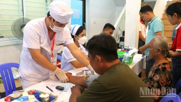 Các y, bác sĩ ân cần khám bệnh cho người dân. (Ảnh: HUY VŨ)