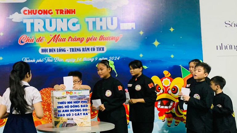 Các em thiếu nhi đóng góp ủng hộ đồng bào miền Bắc bị thiệt hại do bão số 3.