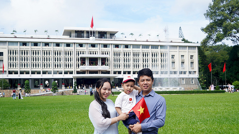 Nhiều gia đình mặc áo dài khi đi tham quan và chụp ảnh trước cửa Dinh Độc Lập.