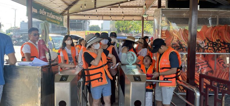 Công tác phục vụ bảo đảm an toàn cho du khách trước khi lên thuyền thăm quan. (Ảnh: Bùi Văn Mạnh)