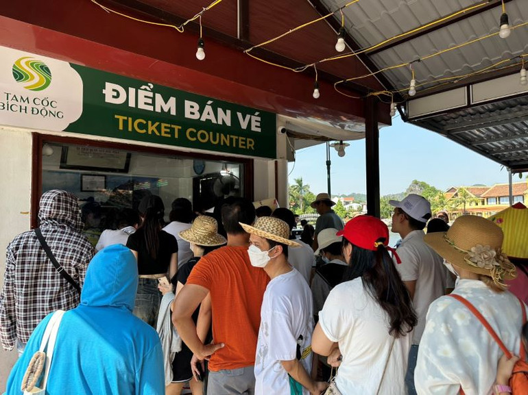 Du khách xếp hàng mua vé tham quan tuyến du lịch Đình Các-Tam Cốc ngày đầu nghỉ lễ. (Ảnh: Bùi Văn Mạnh)