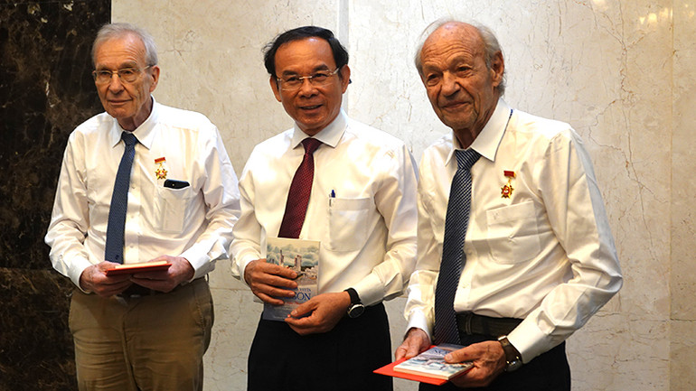 Đồng chí Nguyễn Văn Nên, Ủy viên Bộ Chính trị, Bí thư Thành ủy Thành phố Hồ Chí Minh trao tặng cho ông Olivier Parriaux và ông Bernard Bachelard Huy hiệu Thành phố Hồ Chí Minh.