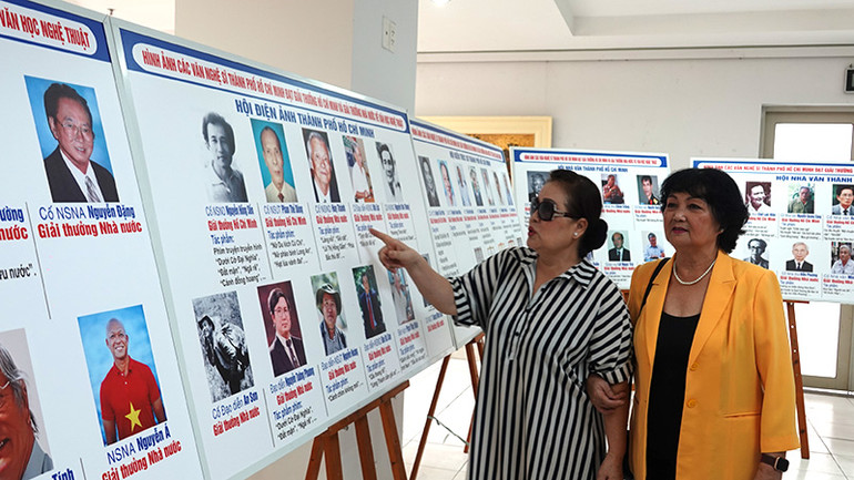 Các nghệ sĩ tham quan triển lãm ảnh.